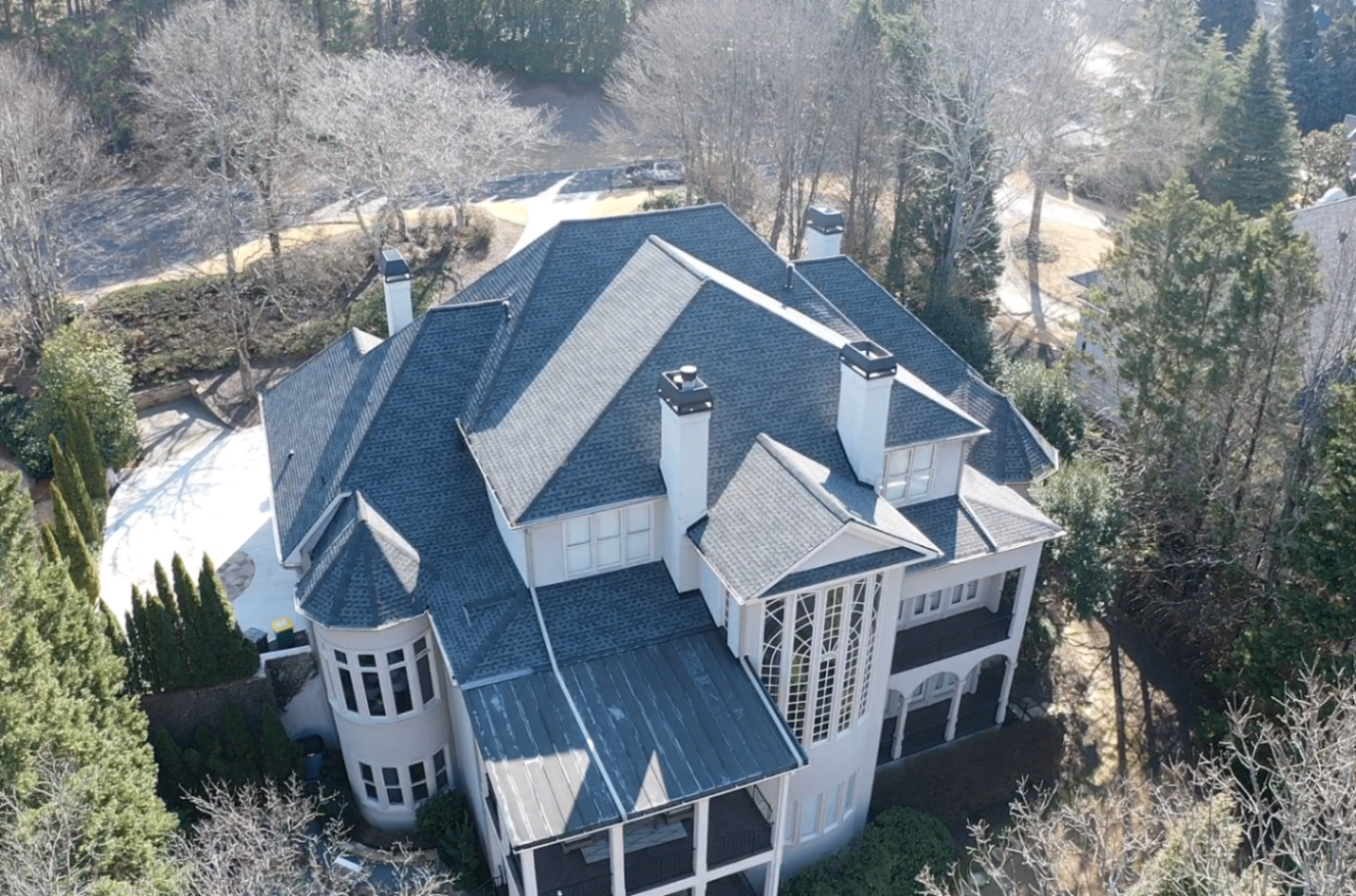 Completed shingle and standing seam roof on a stucco Charlotte home