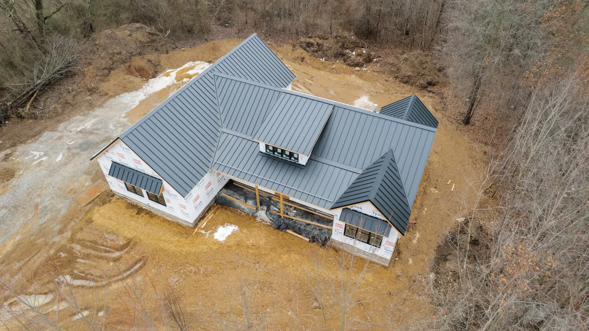 New charcoal standing seam metal roof on a home under construction