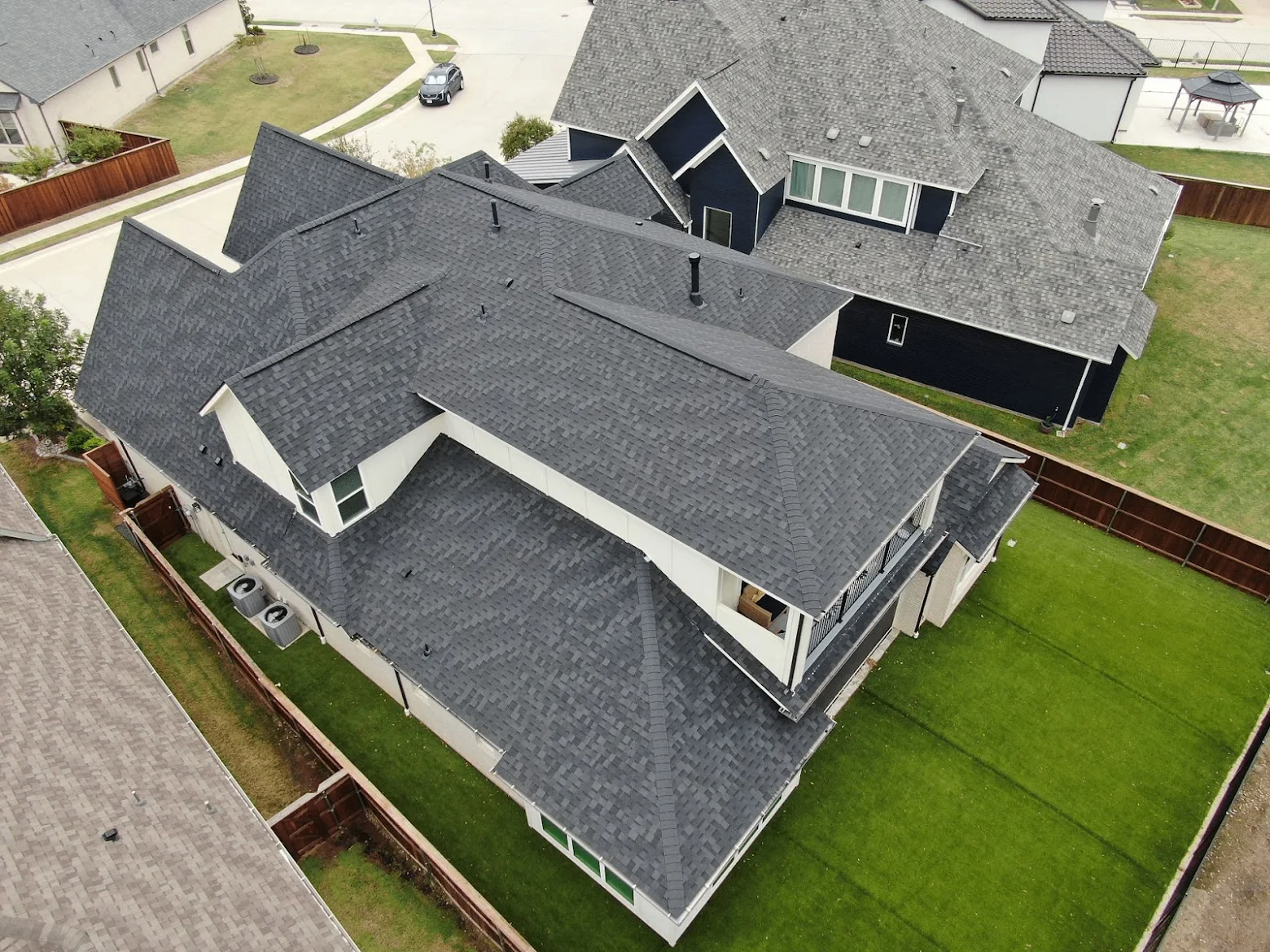 Aerial view of a completed charcoal shingle roof on a modern Charlotte home