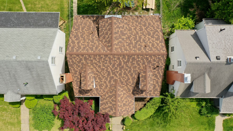 Overhead view of a home before and after a new shingle roof — after