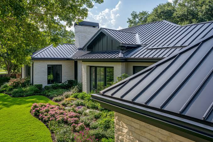 Close view of a dark standing seam metal roof with clean panel lines and gardens