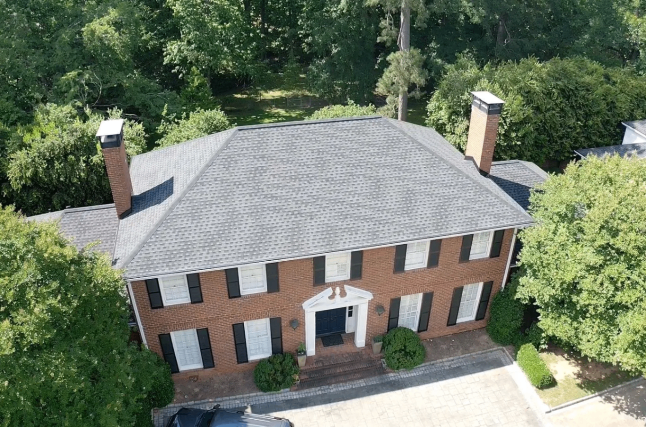 Completed light grey shingle roof on a classic red brick colonial